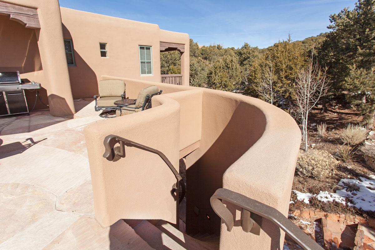 The adobe terrace provides an inviting space with its own unique charm. Its standout feature is a curved adobe staircase, elegantly leading to the lower deck.