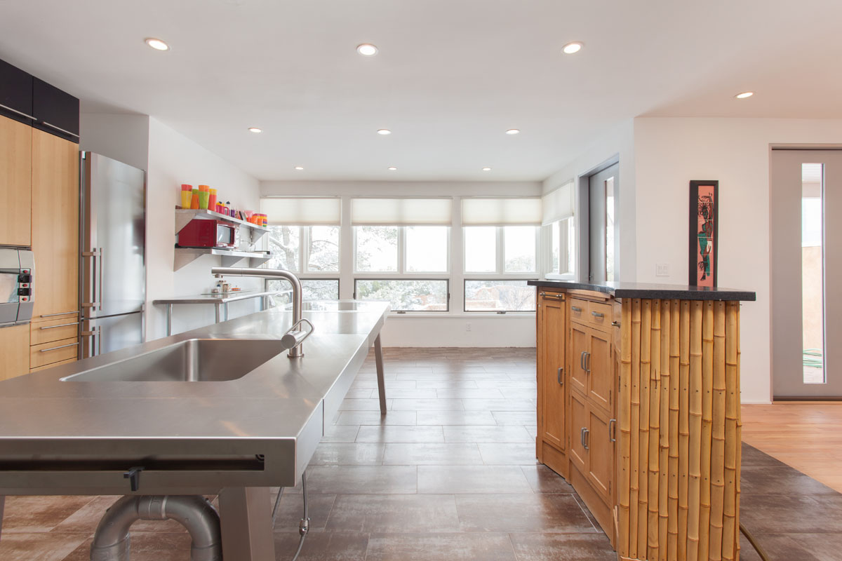 The kitchen exudes a contemporary feel, with its bamboo-slated bar counter, oversized stainless countertop, and built-in freezer. Adding to the functionality and modern design are a hanging condiments organizer and automated roller blinds for the kitchen windows.