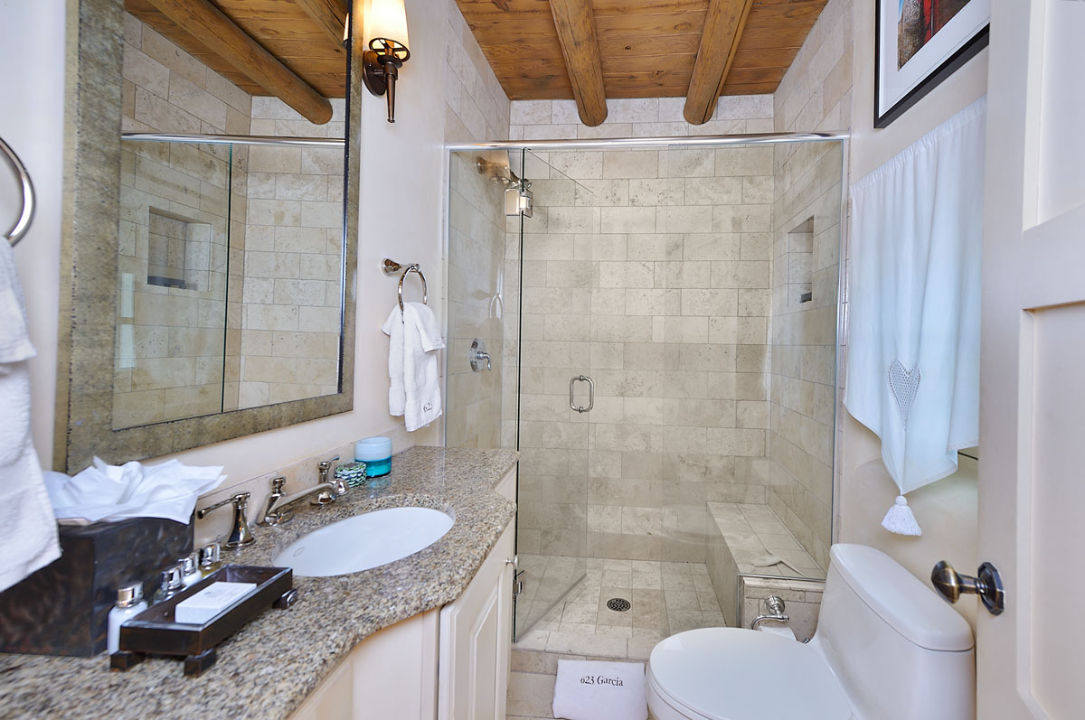 The bathroom complements Mediterranean theme with sophisticated gray granite tiles.