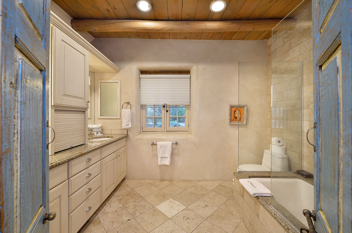 The bathroom complements Mediterranean theme with sophisticated gray granite tiles.