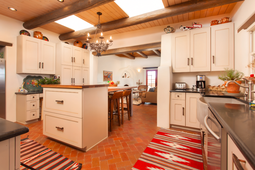 Interior design with a kitchen featuring traditional wood beams, terracotta floor tiles, and rustic decor, embodying architecturally crafted functionality.