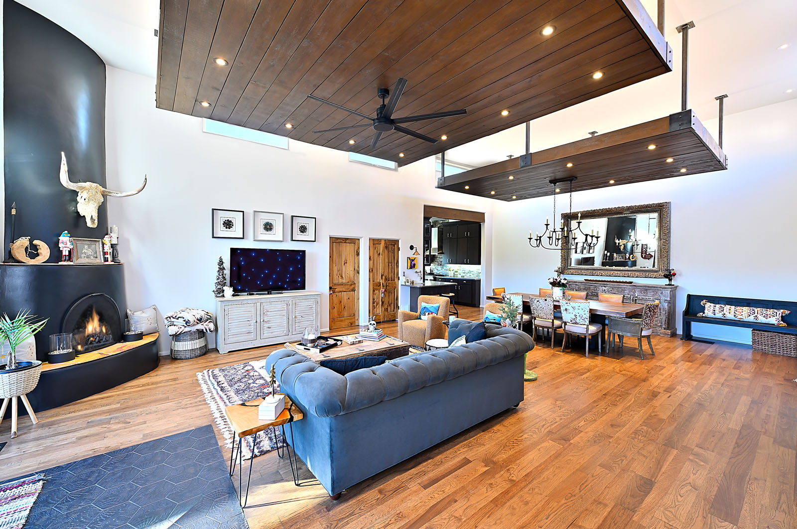 Modern and stylish living room with a dark feature wall, large fireplace, and hardwood floors in a Santa Fe home.