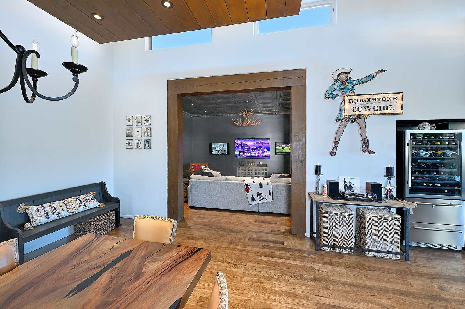 Stylish Santa Fe home interior with a mix of rustic and contemporary decor, featuring a unique cowgirl-themed wall art and a sophisticated wine storage area.