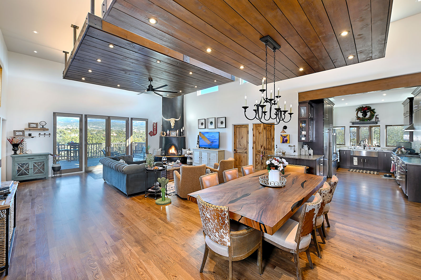 Expansive open-concept living area in a Santa Fe home featuring high wooden ceilings, elegant lighting, and a blend of rustic and modern decor.