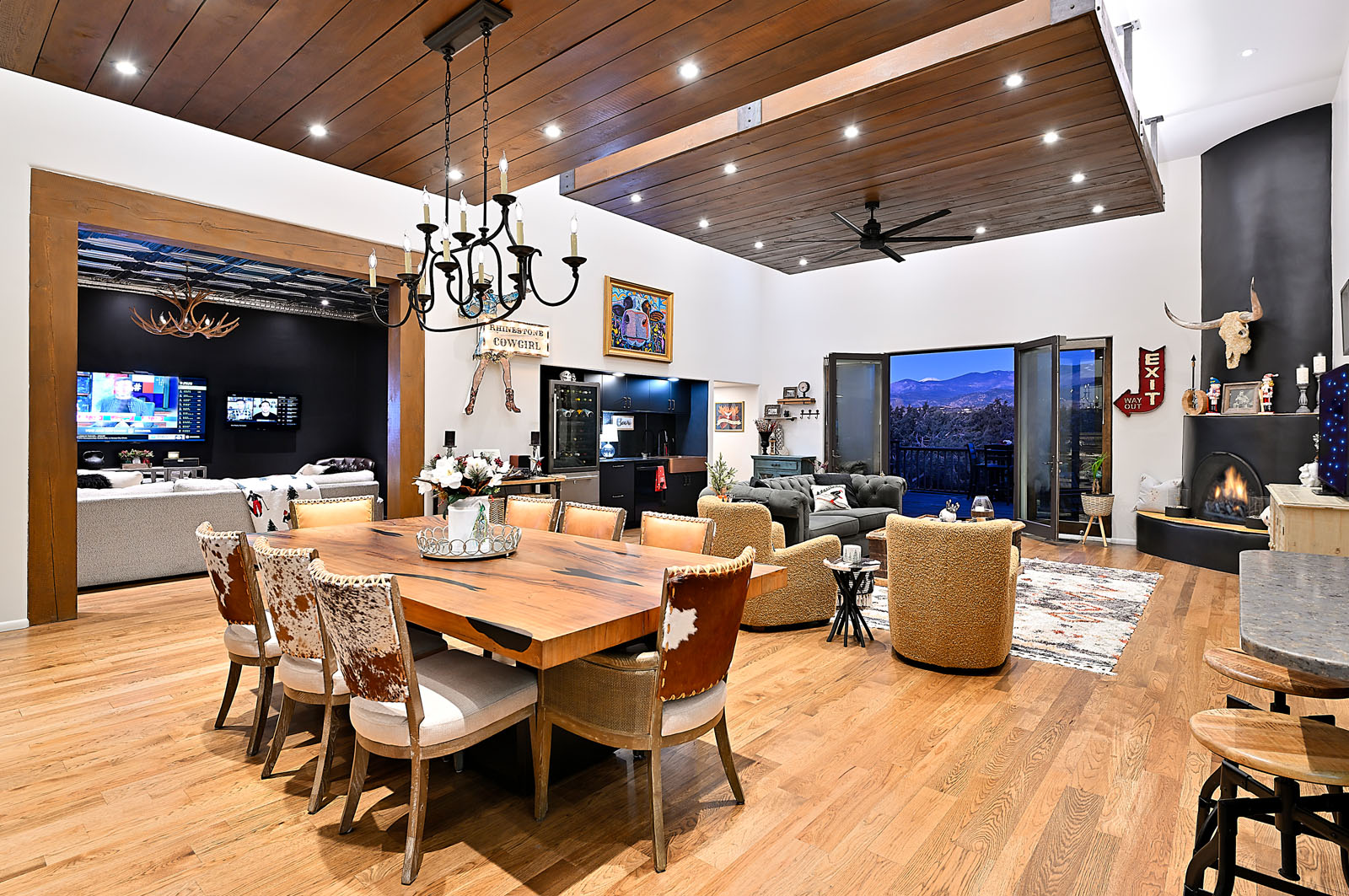 Luxurious and expansive living area in a Santa Fe home, featuring high wooden ceilings, elegant dining setup, and seamless integration with the modern kitchen and cozy lounge spaces.